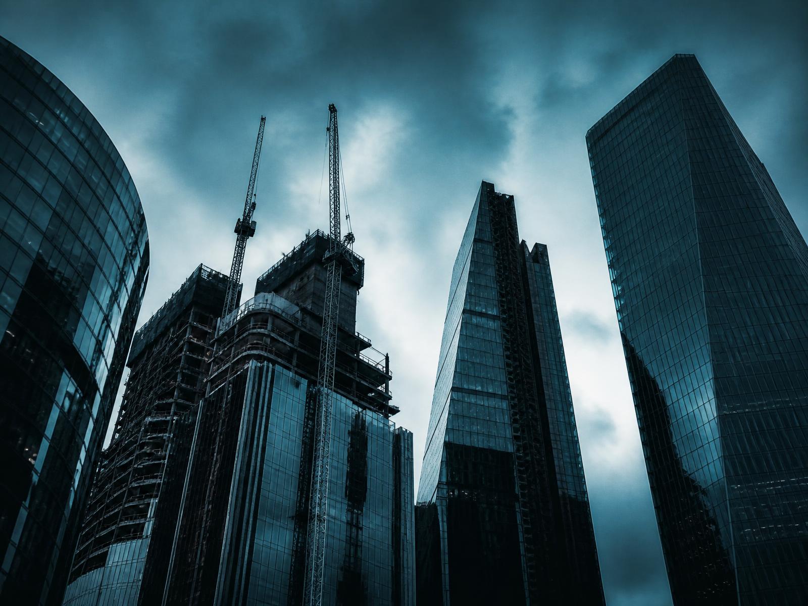 Contemporary towers under construction beside completed high-rise buildings